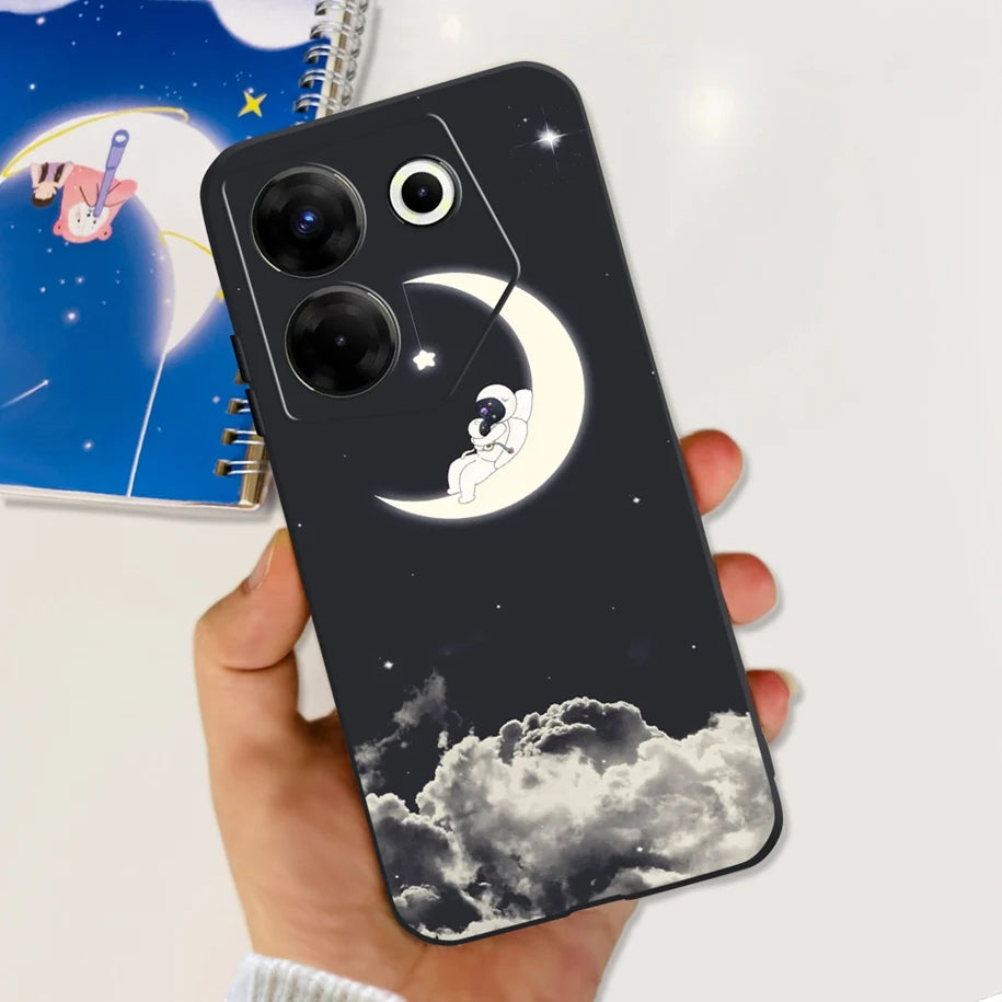 Phone case with moon and cloud design held by a hand, with a notebook in the background.